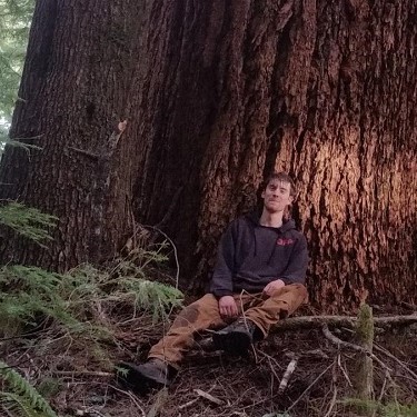 Charles sitting in front of large tree