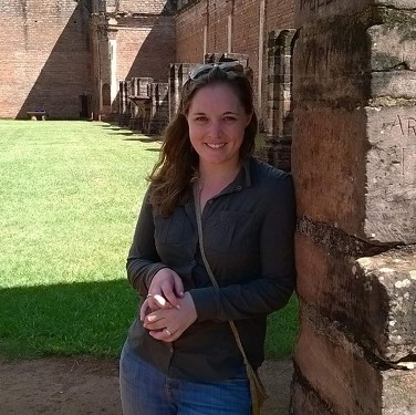 Jenn leaning against a brick wall